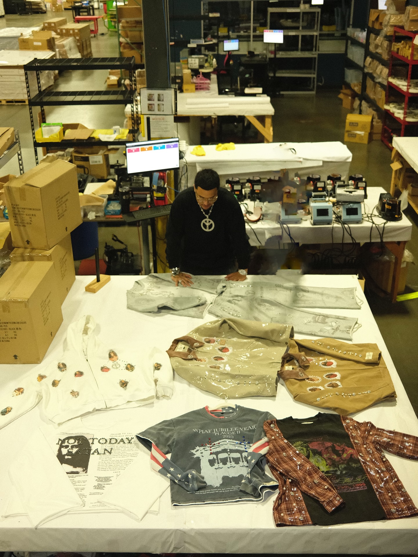 Team member reviewing the finished apparel run on the production table